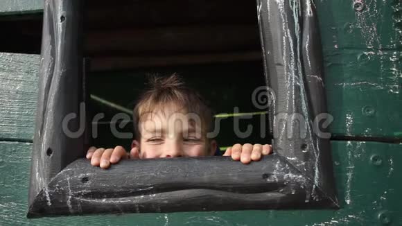 男孩躲在木屋里望着窗外视频的预览图