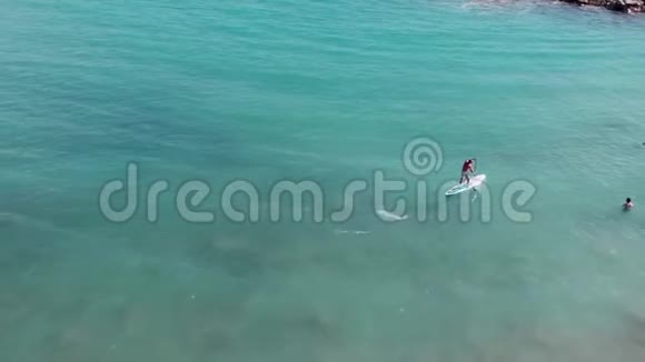年轻的晒太阳的男孩漂浮在游泳运动员附近无人机拍摄的迷人男子冲浪迷人男人的空中景色视频的预览图
