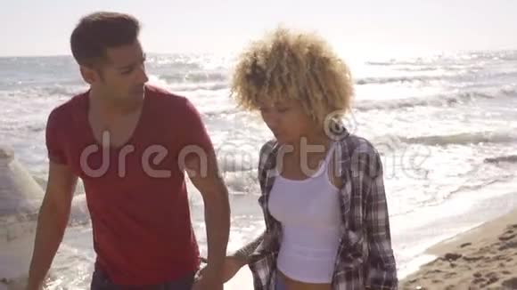 年轻的非裔美国夫妇在海滩上散步视频的预览图