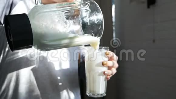 女人从搅拌机里倒出来搅拌机在玻璃里煮维生素鸡尾酒视频的预览图