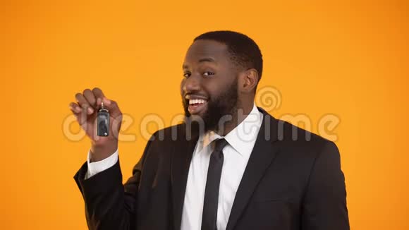 微笑的非裔美国男性展示汽车钥匙租车租赁视频的预览图