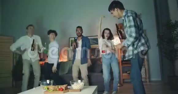 多种族的年轻人在家庭聚会上跳着的瓶子视频的预览图