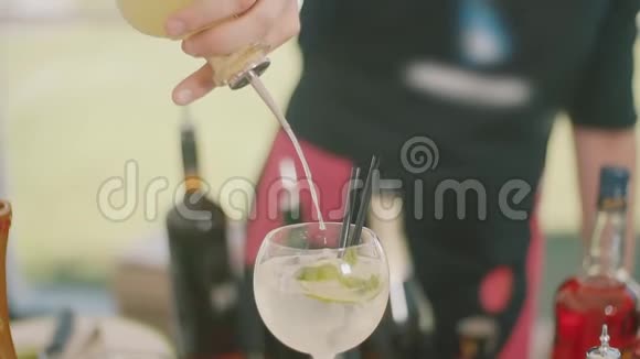 酒保把鸡尾酒倒入装有冰块的杯子里视频的预览图