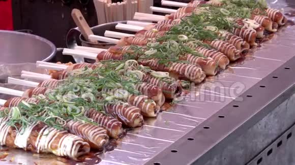 在京都的Nishiki市场奥科诺米亚基用酱油和蛋黄酱做成的木棍和葱头视频的预览图