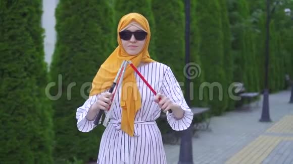 公园里一个戴着头巾手杖的年轻美女的肖像视频的预览图