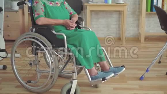 孤独悲伤的老太太戴着眼镜坐在轮椅上视频的预览图