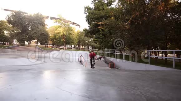 男子骑着BMX自行车在户外滑冰公园从坡道上跳到空中年轻人一个人在空车里视频的预览图