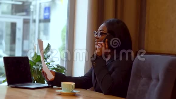 非裔美国女商人手提电脑和纸女孩和生意伙伴通电话视频的预览图