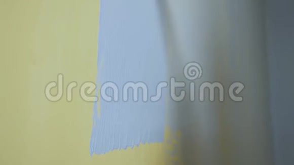 施工滚筒用灰色油漆粉刷黄色墙面视频的预览图
