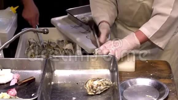 新鲜牡蛎在尼什基市场开放手里拿着牡蛎和一把刀视频的预览图