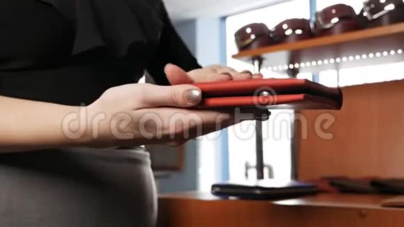 一个女人的手上一个皮夹里面是手工制作的皮制品视频的预览图