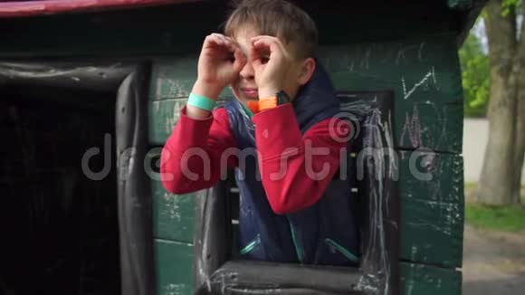 孩子看着他的手模仿望远镜看着窗外视频的预览图