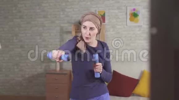 年轻女性癌症患者化疗后戴着哑铃的围巾拳击视频的预览图