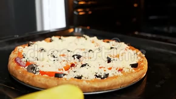 一个女人把披萨放进烤箱在电对流炉里煮意大利披萨带有莫扎拉奶酪的披萨视频的预览图
