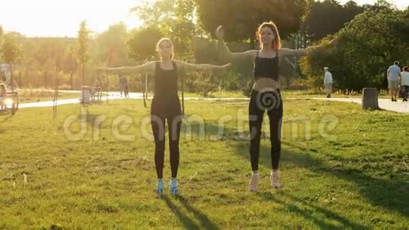 两个运动女孩在阳光公园一起训练健身健美操和伸展运动健康和运动视频的预览图