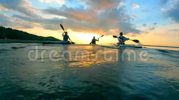 一群人正沿着日落的水域划独木舟视频的预览图
