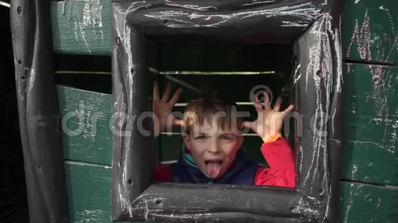 一个少年在木屋里玩耍看着窗外做鬼脸视频的预览图