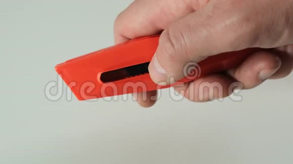 红色文具刀在男性手中开合视频的预览图