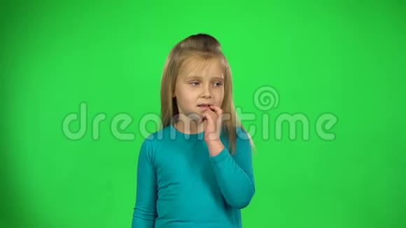 穿蓝色夹克的女孩在绿色背景上悲伤地摆姿势4k视频的预览图