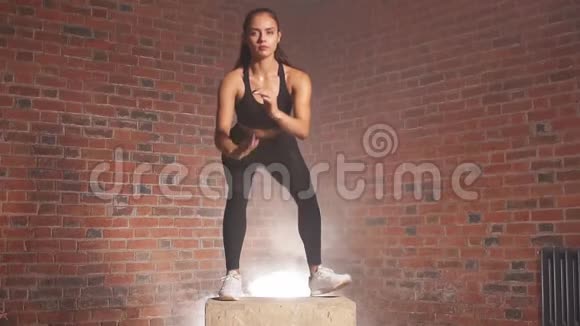 漂亮的女性健美运动员在健身房里跳在合适的盒子上视频的预览图
