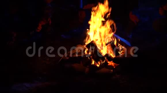 四个人坐在炉火旁在月光下温暖双手讲一些可怕的故事视频的预览图