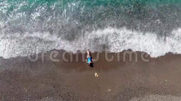 海滨和一位女士在海浪中日光浴暑假概念视频的预览图