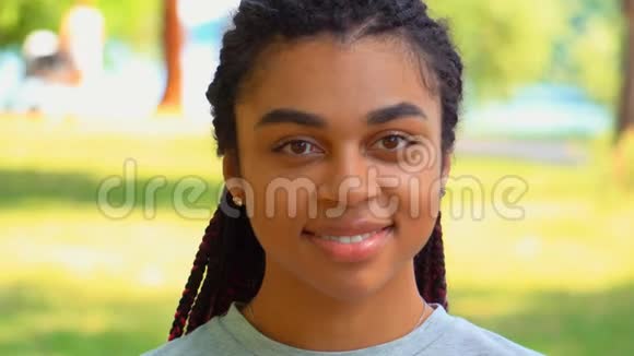 前景特写脸上挂着耳机的欢快的非裔美国年轻女子视频的预览图