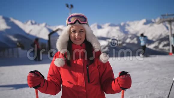 一个穿着滑雪护目镜的红色滑雪服的妇女在滑雪场的肖像视频的预览图