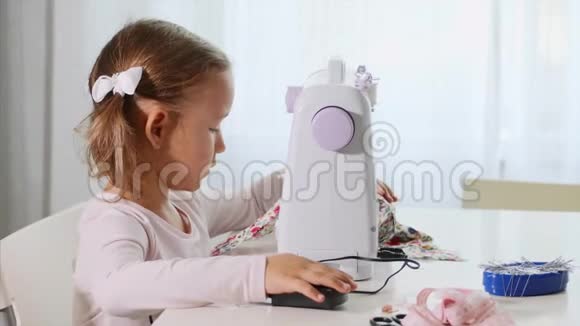 一个小女孩在缝纫一个孩子正在粘布侧围特写视频的预览图