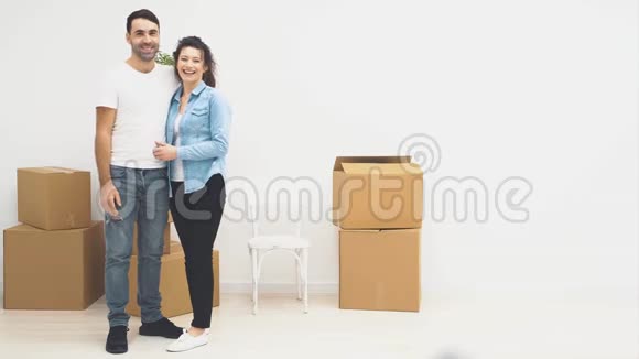 年轻夫妇一起搬到了一间新公寓他们拥抱着依偎着一对夫妇把拇指指伸出来视频的预览图