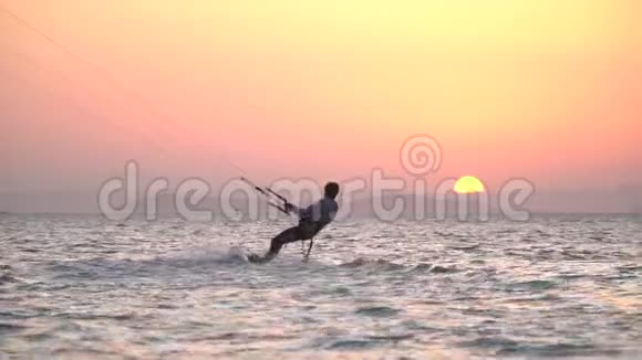 两个风筝冲浪者在海面上滑行背景是日落视频的预览图