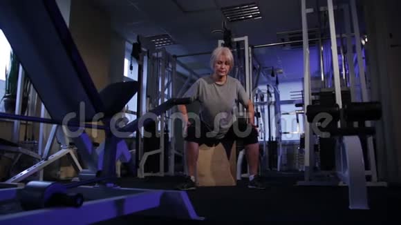 老年妇女进行等距锻炼跪在两侧和背部正面观看复制空间视频的预览图