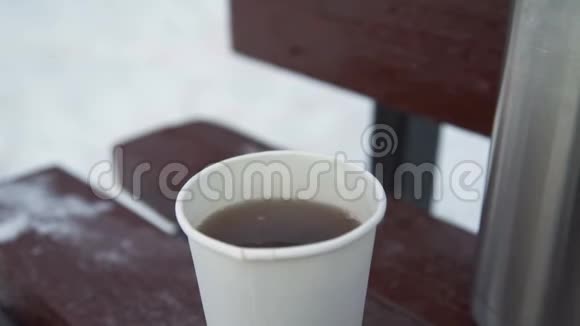 冬天的长凳上放着一杯茶视频的预览图