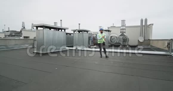 在建筑工地的屋顶上一位建筑师兴奋地跳舞他戴着安全帽做生意视频的预览图
