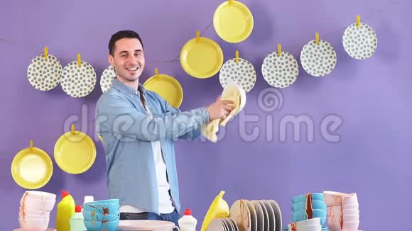 英俊开朗的男人在厨房用毛巾擦盘子视频的预览图