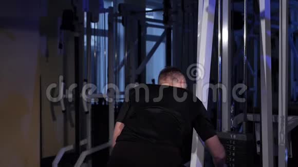下拉床一个年轻人在模拟器上做背部肌肉锻炼视频的预览图