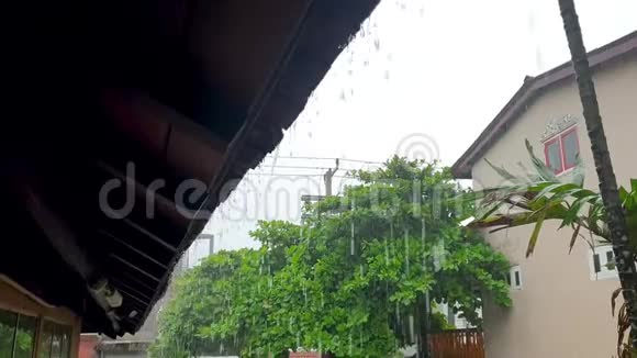 亚洲岛屿热带降雨期间从屋顶流出的水滴和水流的4k镜头视频的预览图