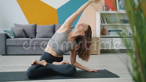 在莲花姿势瑜伽练习中放松身心的无忧无虑的女人视频的预览图