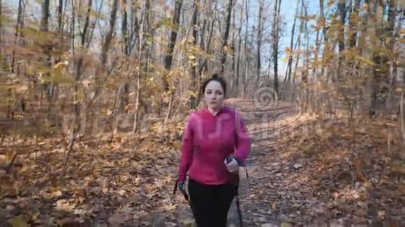 北欧漫步秋林城市公园里有体育杆的年轻胖女人训练视频的预览图
