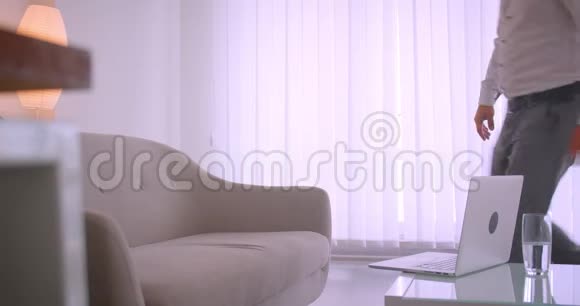 特写侧视图有关的成年白种人商人在笔记本电脑上打字悠闲地坐在办公室的沙发上视频的预览图