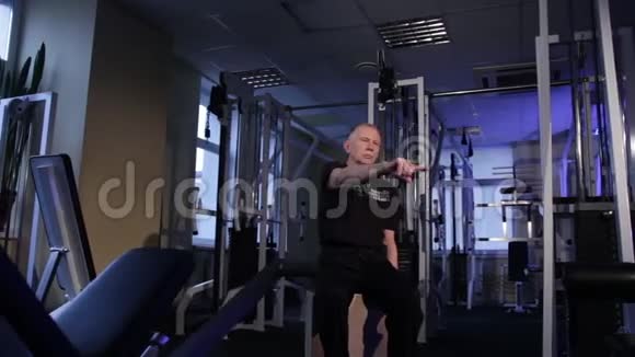 一个同龄的人在健身房为所有的身体做关节体操食指追踪复制空间视频的预览图