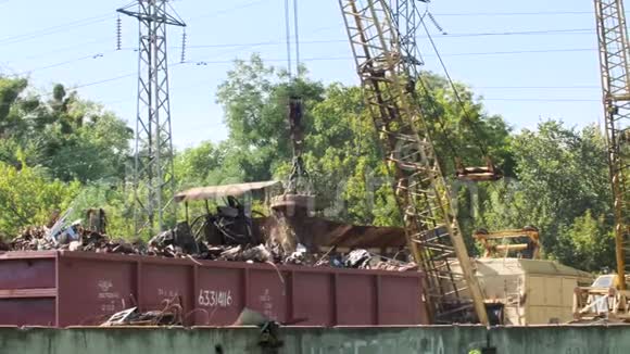 大型工业磁铁提升废铁在废料场上的4k视频金属回收概念视频的预览图
