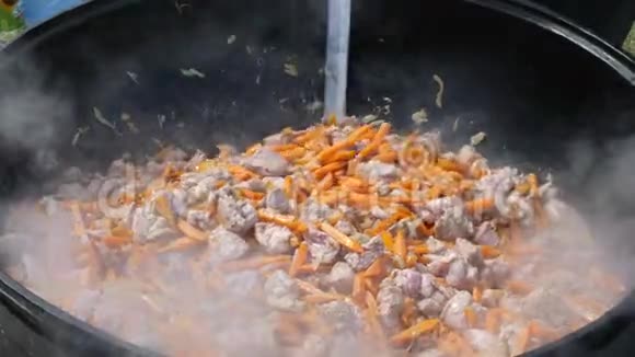 将猪肉和胡萝卜片放入锅中煮熟视频的预览图