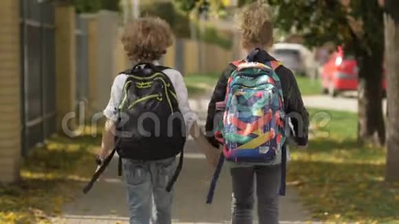 两个女孩和男孩在城市街道上走过汽车妹妹和她的哥哥回学校太阳在后台视频的预览图