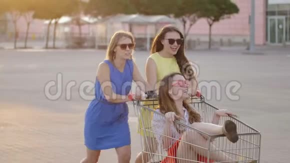 在明亮的日子里朋友们在商场停车场娱乐精力充沛的女人围着迷人的开朗的女孩在购物视频的预览图