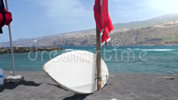 4k视频冲浪板躺在空海滩与黑色火山沙附近海洋视频的预览图