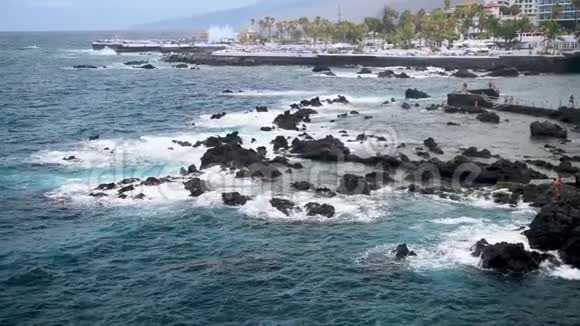 美丽的海景海浪打破黑色岩石和悬崖在海滨小镇克鲁兹港景观视频的预览图