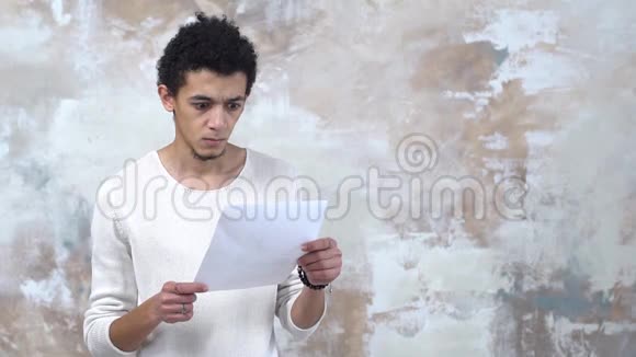 一个年轻人独自被隔离在墙上皱巴巴的合同愤怒地扔掉视频的预览图