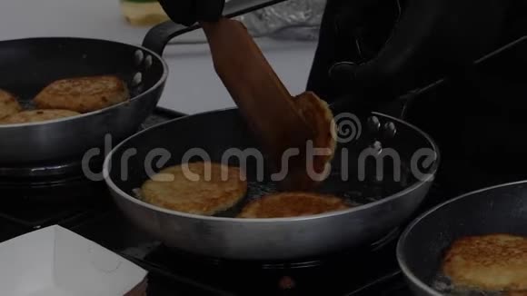 在锅中用煮沸的油包围着的厨师为汉堡烹制肉切片视频的预览图