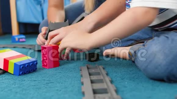 4k小男孩与妈妈一起组装玩具铁路的特写视频视频的预览图